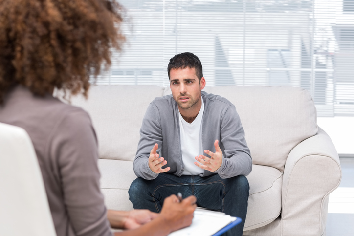 man sitting talking to a therapist