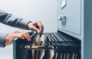 man rifling through a file cabinet