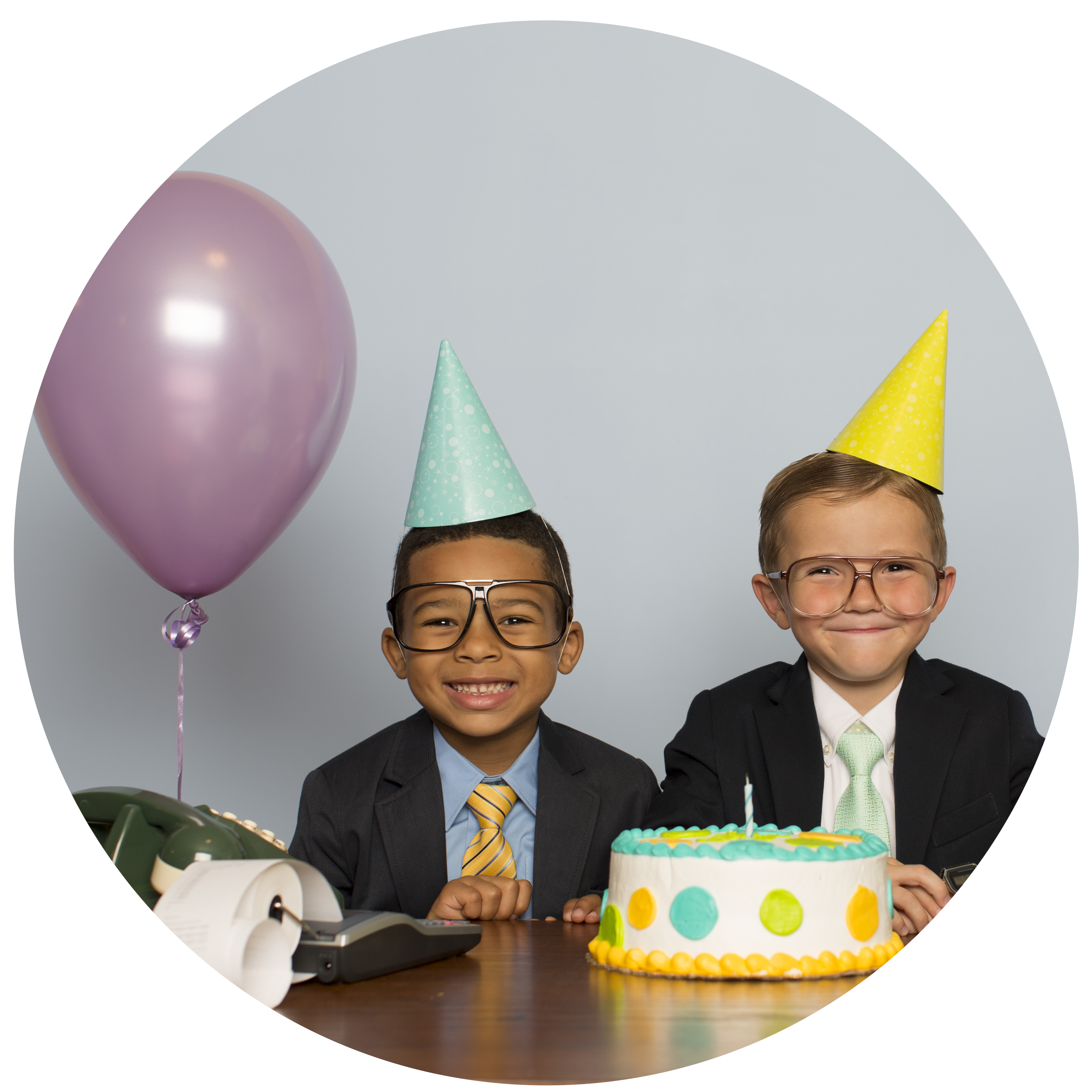 kids in business suits with party hats, balloon, and cake