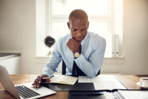 man sitting on computer thinking