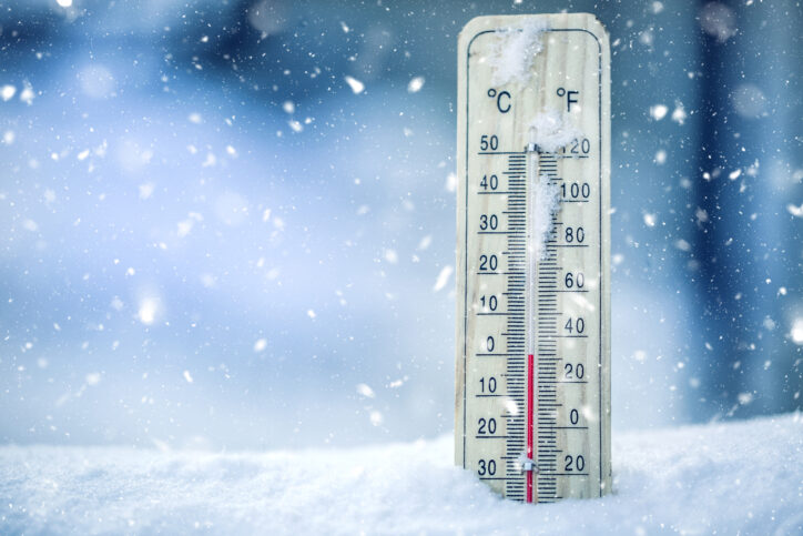 thermometer in snow showing a temperature of zero